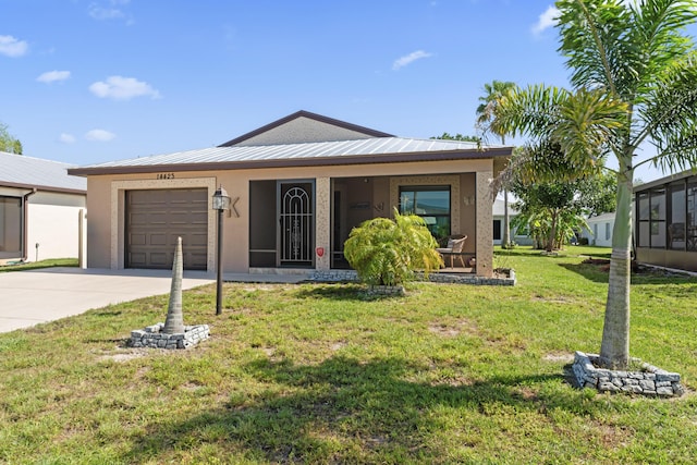 14423 Dalia Ave, Fort Pierce, FL 34951 - ranch-style home with an attached garage, metal roof, concrete driveway, stucco siding, and a front lawn