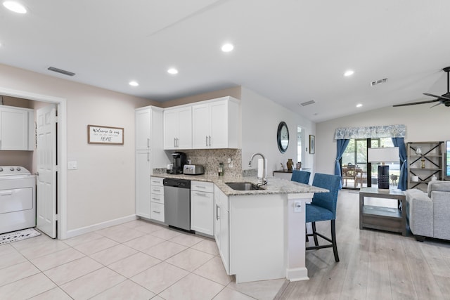 14423 Dalia Ave, Fort Pierce, FL 34951 - kitchen featuring a sink, open floor plan, a kitchen bar, stainless steel dishwasher, and washer / dryer