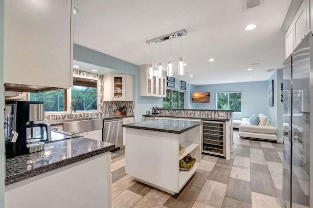 2416 NW 32nd St, Boca Raton, FL 33431 - kitchen with wine cooler, appliances with stainless steel finishes, a sink, decorative backsplash, and white cabinetry