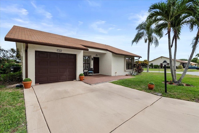 ranch-style home with concrete driveway, a front lawn, a garage, and stucco siding