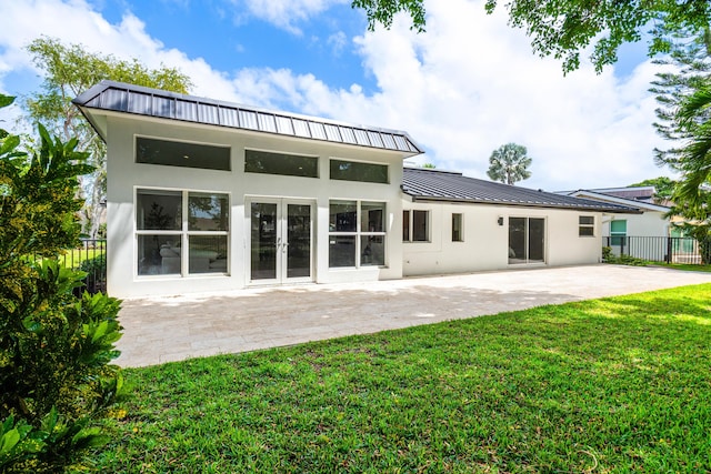 654 Lakewoode Cir W, Delray Beach, FL 33445 - rear view of house featuring a standing seam roof, stucco siding, a patio area, and a metal roof