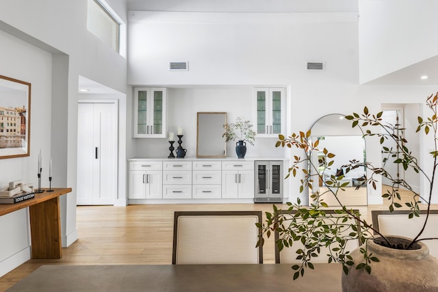 654 Lakewoode Cir W, Delray Beach, FL 33445 - living area with wine cooler, a high ceiling, and light wood-style floors