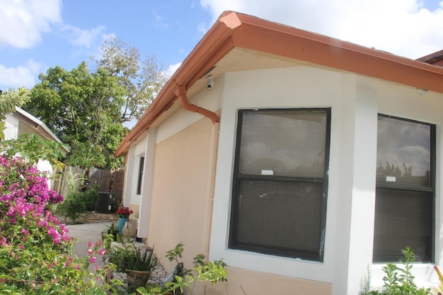 view of property exterior with fence and stucco siding