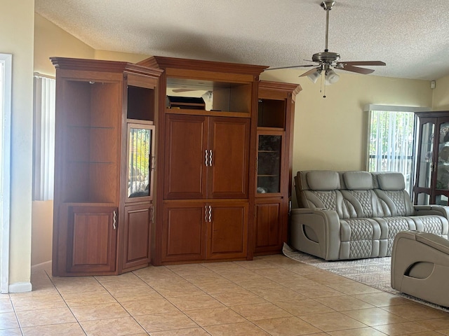 unfurnished living room featuring a textured ceiling, light tile patterned floors, and a ceiling fan