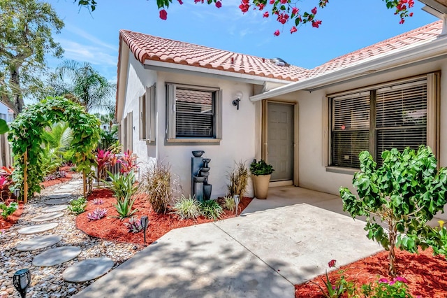 21687 Cromwell Cir, Boca Raton, FL 33486 - property entrance featuring a patio area, a tiled roof, and stucco siding