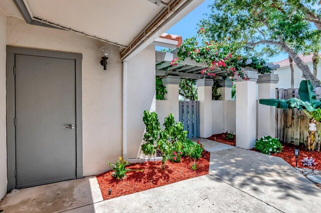 21687 Cromwell Cir, Boca Raton, FL 33486 - entrance to property featuring stucco siding, fence, a patio area, and a pergola