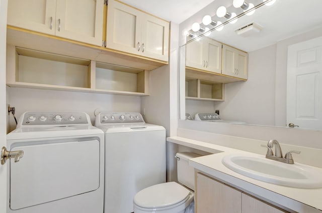 bathroom featuring toilet, washer and clothes dryer, and vanity