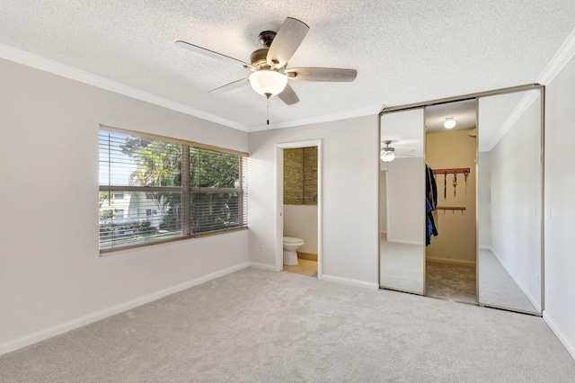 unfurnished bedroom featuring crown molding, carpet floors, baseboards, and a textured ceiling
