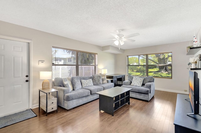 living room featuring a healthy amount of sunlight, ceiling fan, and hardwood / wood-style flooring