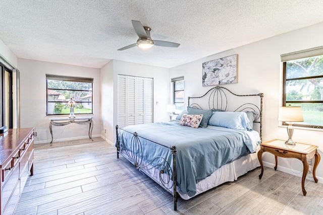bedroom with multiple windows, ceiling fan, and light wood-type flooring