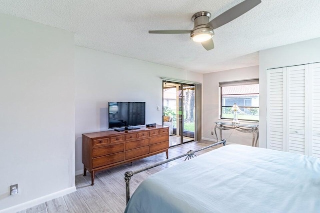 bedroom with access to outside, light wood-style flooring, a textured ceiling, a ceiling fan, and baseboards