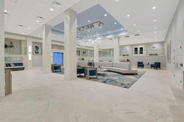 living area with decorative columns, visible vents, and recessed lighting