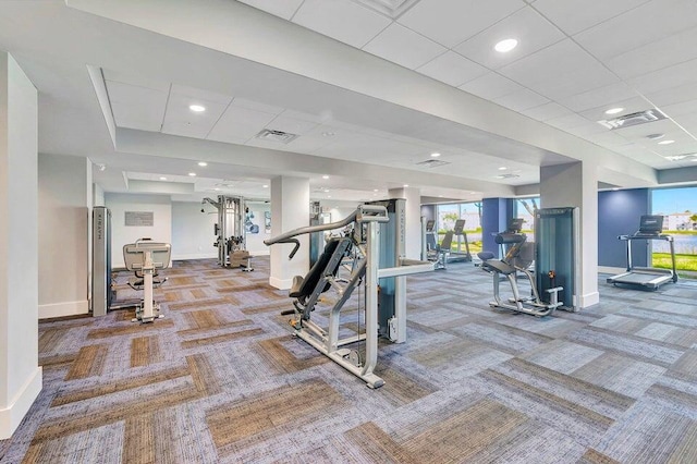 exercise room featuring carpet flooring, visible vents, baseboards, and a paneled ceiling