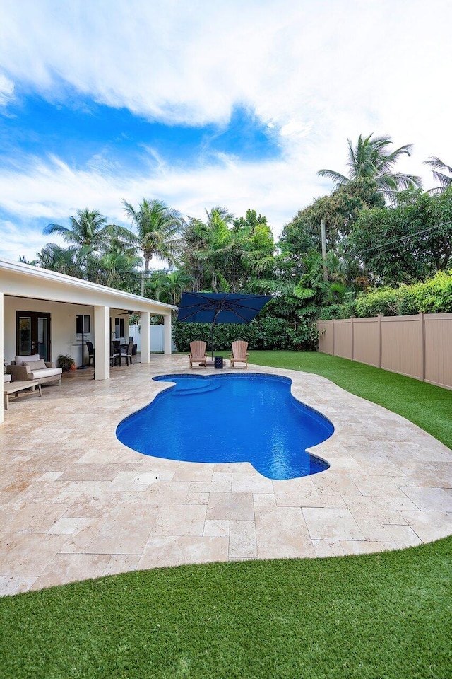 view of pool featuring a lawn, a fenced backyard, a patio, an outdoor hangout area, and a fenced in pool