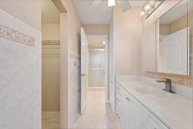 336 Golfview Rd Unit 916, North Palm Beach, FL 33408 - full bath with vanity, a stall shower, a spacious closet, tile patterned flooring, and a textured ceiling