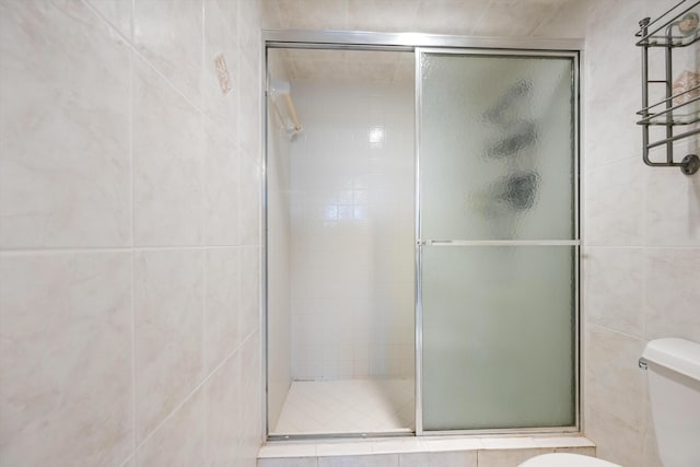 336 Golfview Rd Unit 916, North Palm Beach, FL 33408 - full bathroom with a shower stall, tile walls, and toilet