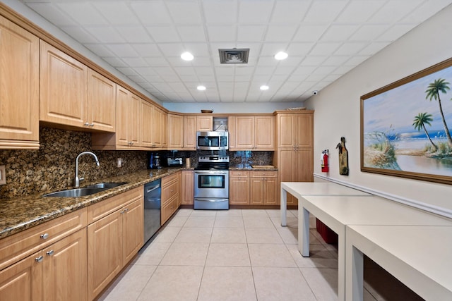 336 Golfview Rd Unit 916, North Palm Beach, FL 33408 - kitchen with appliances with stainless steel finishes, dark stone countertops, light tile patterned flooring, decorative backsplash, and a sink