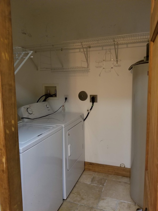 washroom featuring water heater, baseboards, independent washer and dryer, laundry area, and stone finish flooring