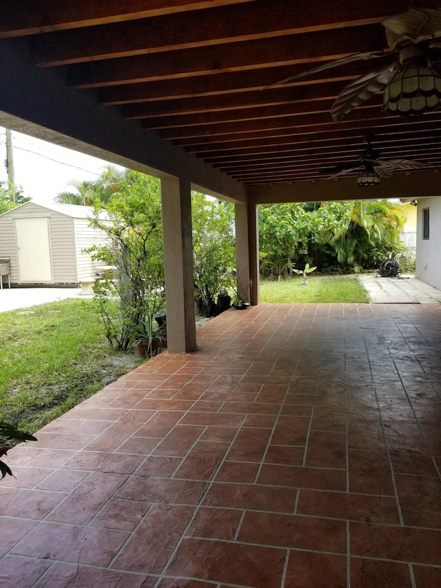 view of patio featuring a shed, an outbuilding, and ceiling fan