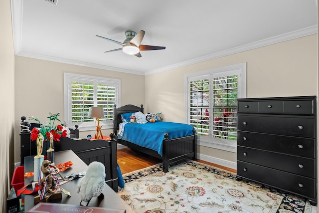 bedroom featuring multiple windows, crown molding, and wood finished floors