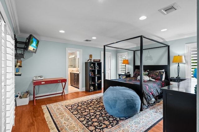 bedroom with crown molding, wood finished floors, visible vents, and recessed lighting