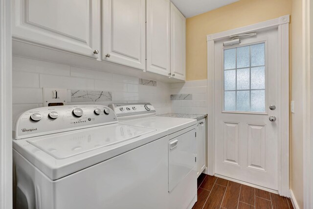 washroom featuring cabinet space, independent washer and dryer, and wood tiled floor
