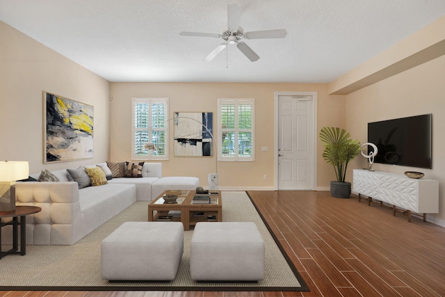 living area with baseboards, a ceiling fan, and wood finished floors