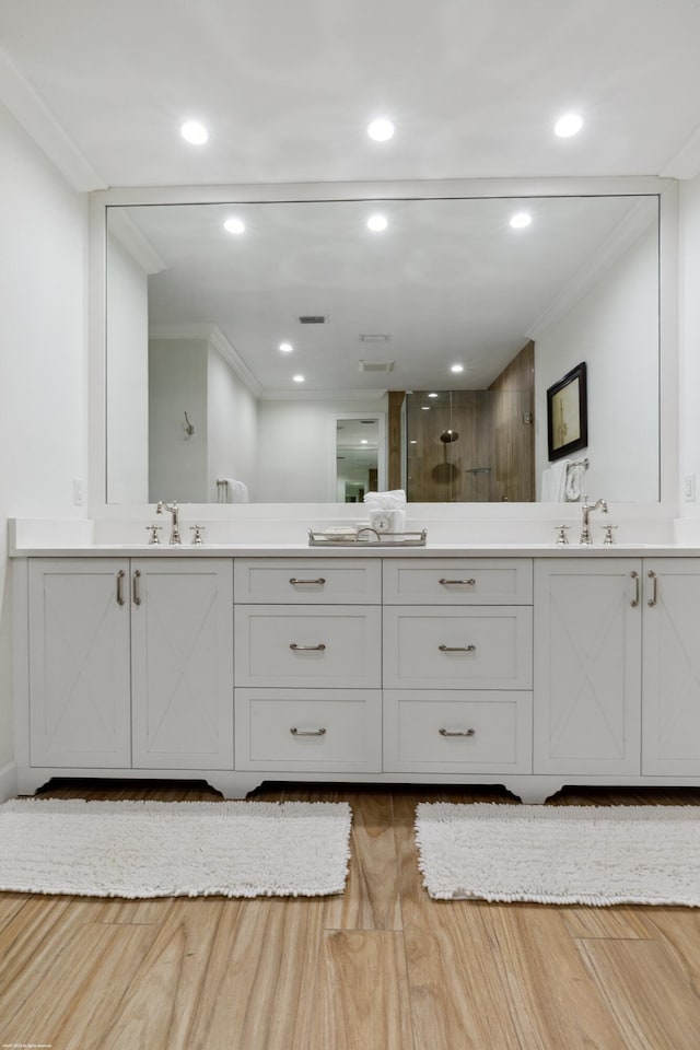 13268 Polo Club Rd Unit A104, Wellington, FL 33414 - bathroom featuring tiled shower, ornamental molding, wood finished floors, a sink, and double vanity