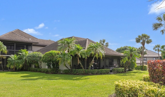 13268 Polo Club Rd Unit A104, Wellington, FL 33414 - rear view of property featuring stucco siding, a sunroom, a lawn, and a tile roof