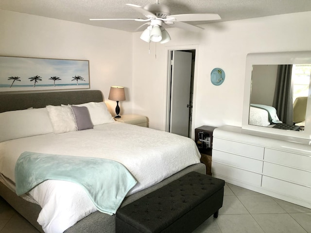 tiled bedroom featuring a ceiling fan and a textured ceiling