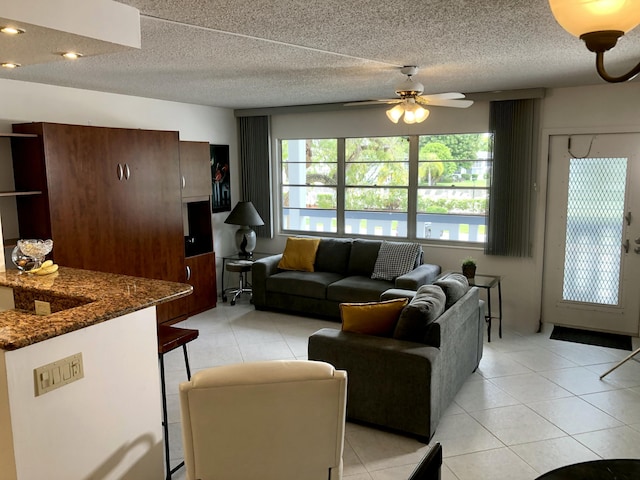 living area featuring ceiling fan and light tile patterned floors
