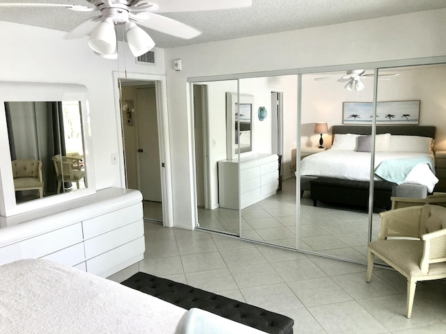 bedroom featuring light tile patterned floors, a closet, visible vents, and a textured ceiling