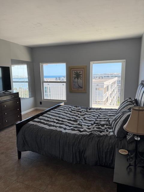 bedroom with baseboards and tile patterned flooring