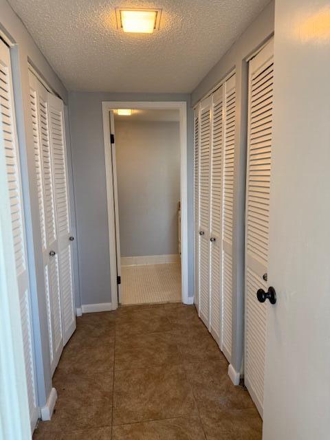 hall featuring a textured ceiling