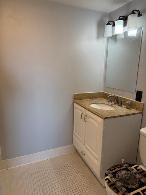 bathroom featuring baseboards, toilet, vanity, and tile patterned floors