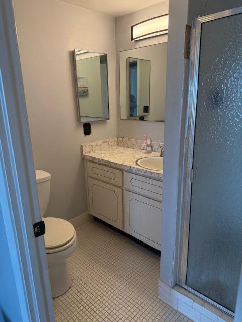 full bathroom featuring tile patterned flooring, toilet, vanity, and a stall shower