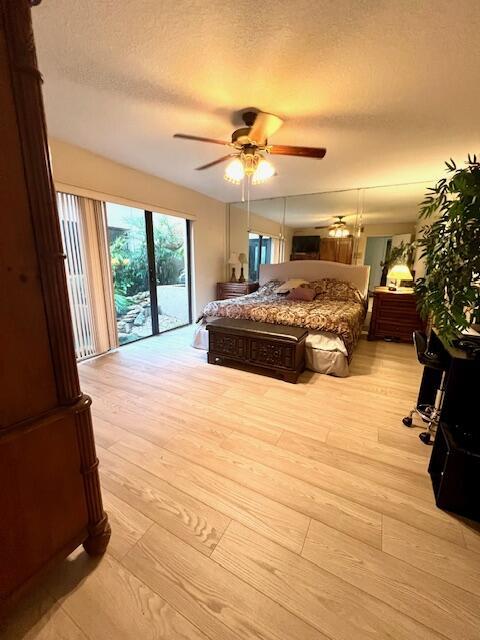 6582 Patio Ln, Boca Raton, FL 33433 - bedroom featuring access to outside, light wood-style floors, a textured ceiling, and a ceiling fan