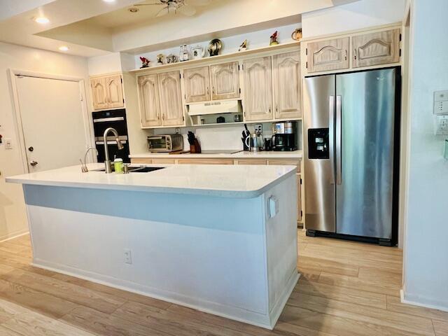 6582 Patio Ln, Boca Raton, FL 33433 - kitchen with stainless steel fridge, a sink, light wood finished floors, light countertops, and recessed lighting
