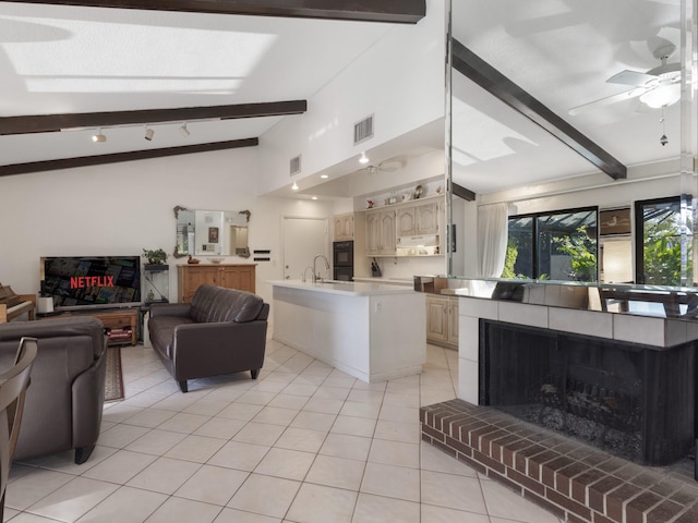 living room featuring vaulted ceiling with beams, visible vents, light tile patterned floors, and a ceiling fan
