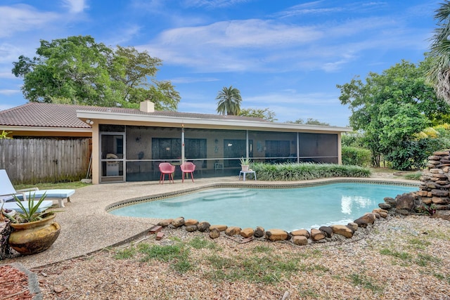 8933 NW 3rd Ct, Coral Springs, FL 33071 - back of property with a sunroom, a patio area, fence, an outdoor pool, and a chimney
