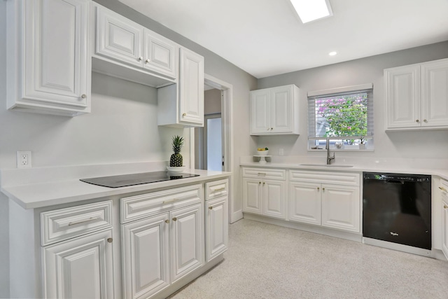kitchen with black appliances, a sink, white cabinets, light countertops, and recessed lighting