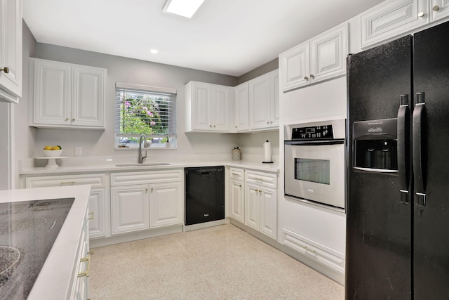 kitchen with black appliances, a sink, white cabinetry, light colored carpet, and recessed lighting