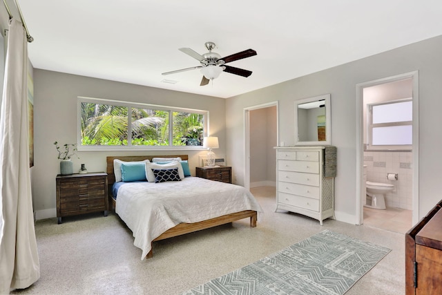 bedroom featuring baseboards, a ceiling fan, and ensuite bathroom