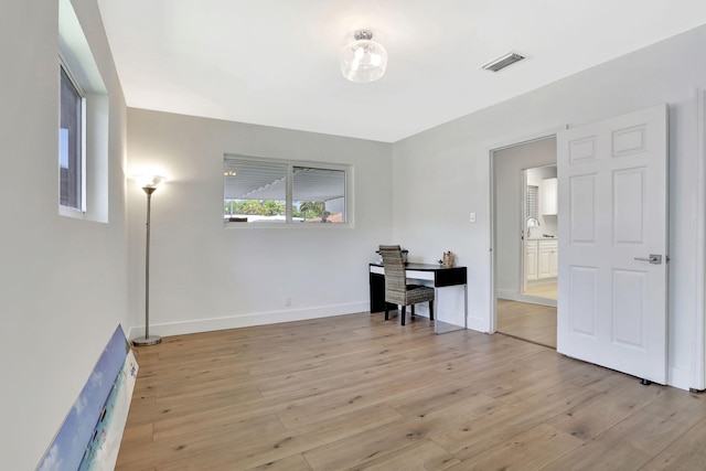home office featuring light wood-style flooring and baseboards