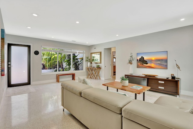 living room featuring baseboards, dark speckled floor, and recessed lighting