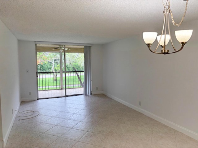 6935 Huntington Ln Unit 205, Delray Beach, FL 33446 - empty room featuring a textured ceiling, a chandelier, and baseboards