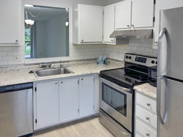6935 Huntington Ln Unit 205, Delray Beach, FL 33446 - kitchen featuring stainless steel appliances, under cabinet range hood, a sink, light countertops, and white cabinetry