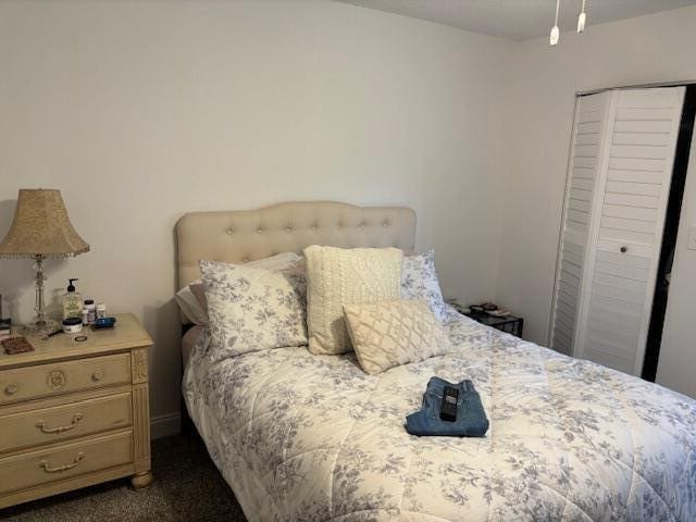 bedroom with dark carpet, a closet, and ceiling fan