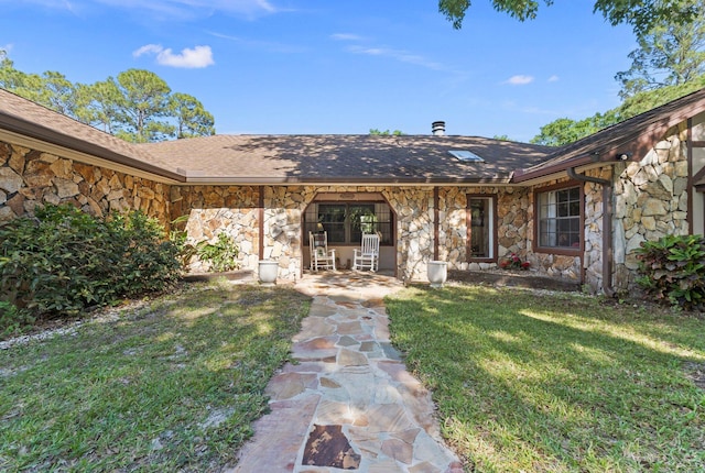 6045 Whipoorwill Ln, Fort Pierce, FL 34987 - property entrance with stone siding, a yard, and roof with shingles