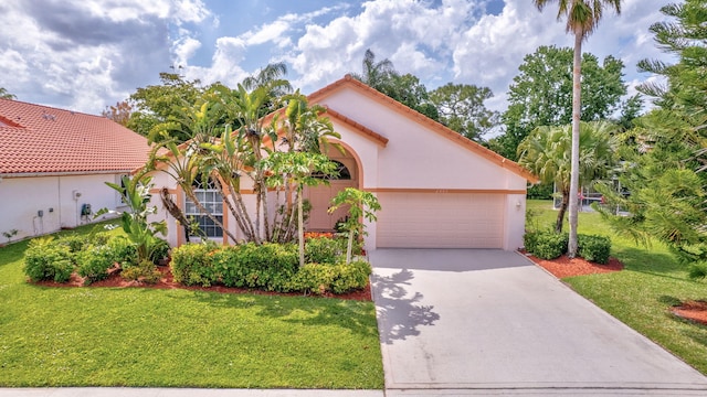 2445 Stonegate Dr, Wellington, FL 33414 - mediterranean / spanish home featuring concrete driveway, a front yard, stucco siding, and a garage